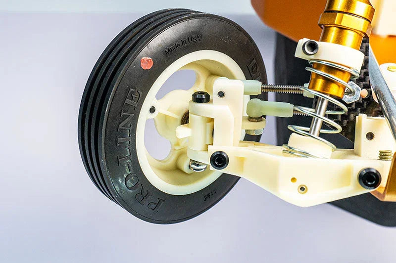 Close-up of RC car front wheel with Pro-Line tire, suspension, and shock absorber