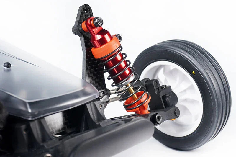 Close-up of RC car suspension shock absorber, orange spring, and front wheel