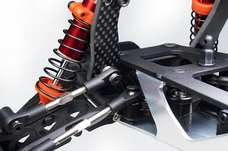 Close-up of RC car suspension system with red aluminum shocks and carbon fiber components