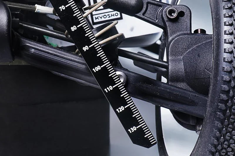 RC car suspension with droop gauge tool measuring travel and tire detail