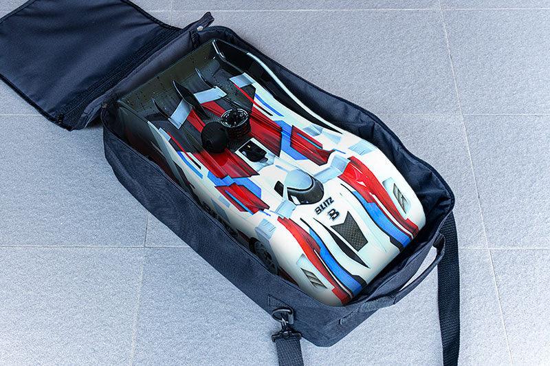 RC race car with red, blue, and white body stored inside a black carrying bag on tile floor