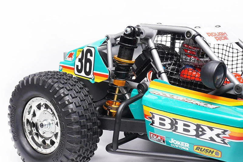 Close-up of RC car buggy with large off-road tire, shock absorber, and BBX decals