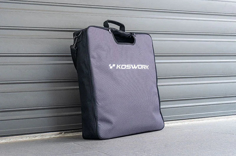 Koswork RC pit bag with handles, standing upright on pavement in front of a garage door