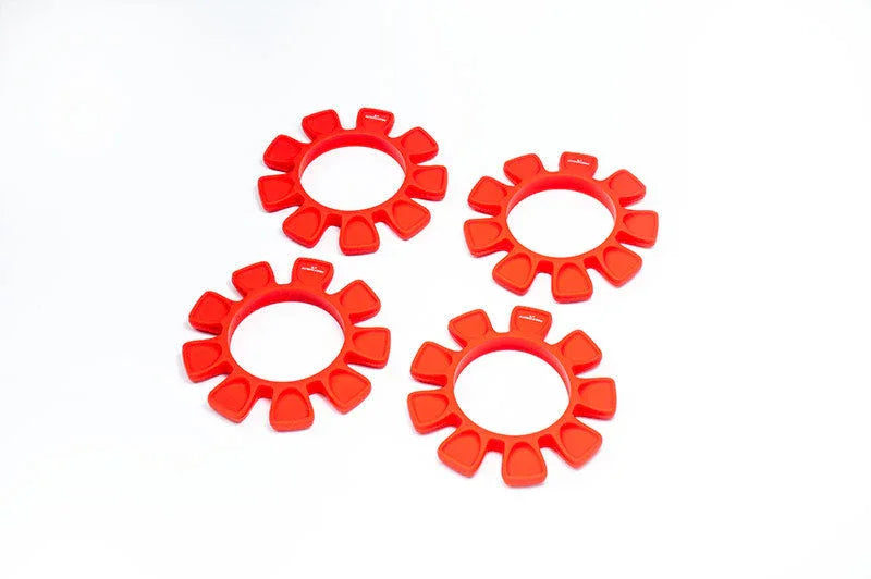 Set of four red RC wheel balancing foam inserts on white background