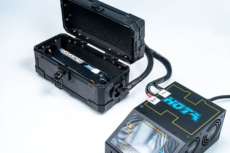 RC battery storage safety box connected to a battery charger on white background