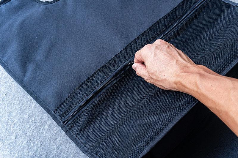 Hand opening black RC pit bag zippered mesh pocket on flat surface