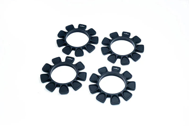Set of four black RC car tire inserts with petal-shaped segments on white background