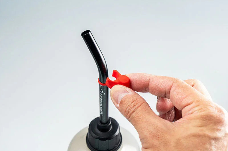 Koswork RC fuel bottle with black spout, red cap, and hand adjusting accessory.