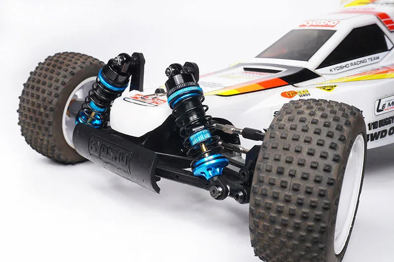 Close-up of RC car front suspension, showing blue aluminum shocks and knobby tires