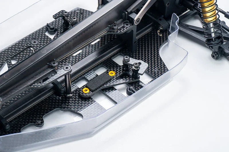 Close-up of carbon fiber RC car chassis with suspension and precision parts visible