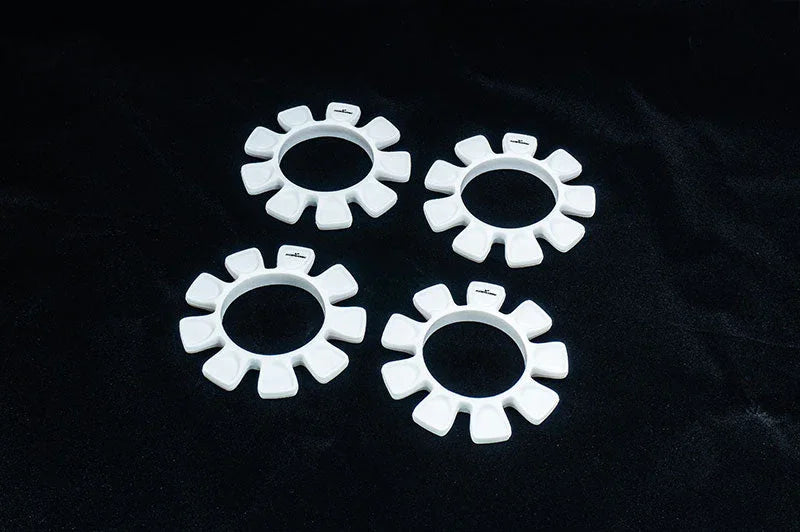 Set of four white RC car tire gluing tools on black background