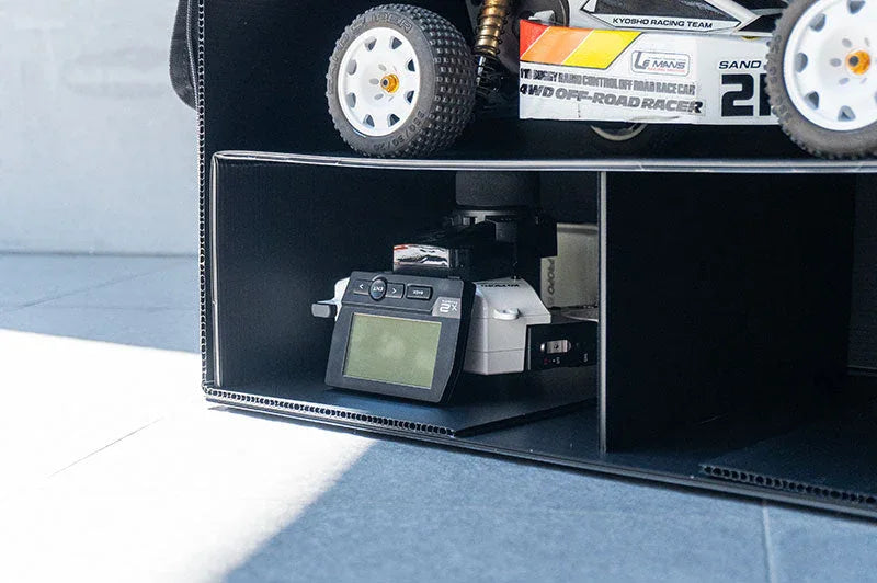RC car and radio controller stored in a black pit bag with organized compartments