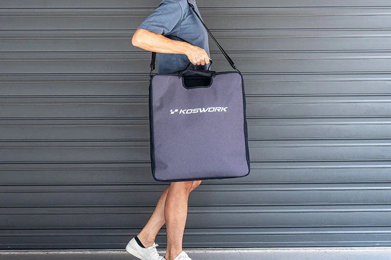 Person carrying a large Koswork RC pit bag with shoulder strap in front of a garage door