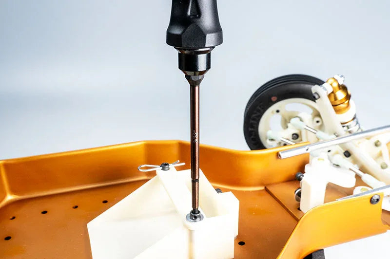 Koswork RC car precision hex driver tool in use on gold aluminum chassis, close-up