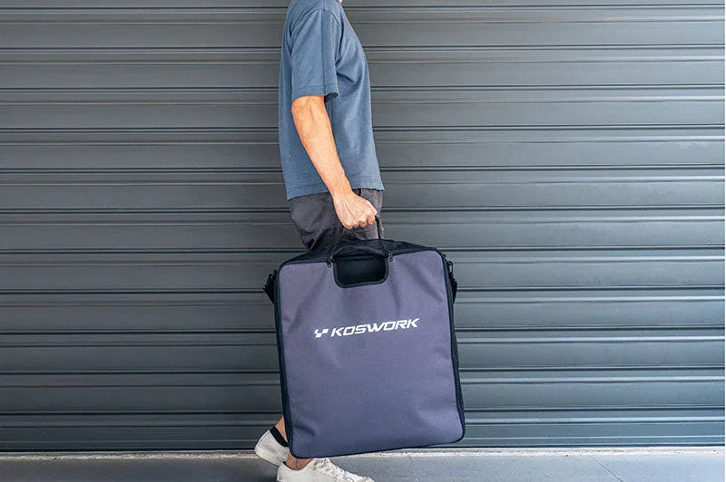 Person carrying large Koswork RC pit bag in front of gray garage door