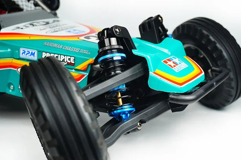 Close-up of RC car front suspension, colorful chassis, racing wheels, shock absorbers visible.