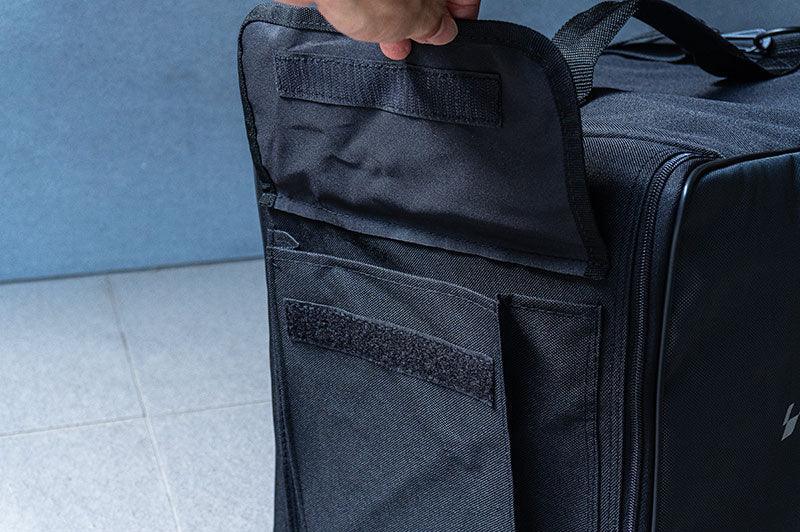 Close-up of a black RC pit bag with open Velcro pocket, durable fabric, and carrying handle