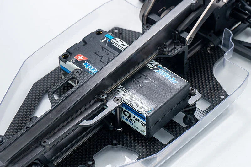 Closeup of RC car chassis with carbon fiber plate and electronic components installed