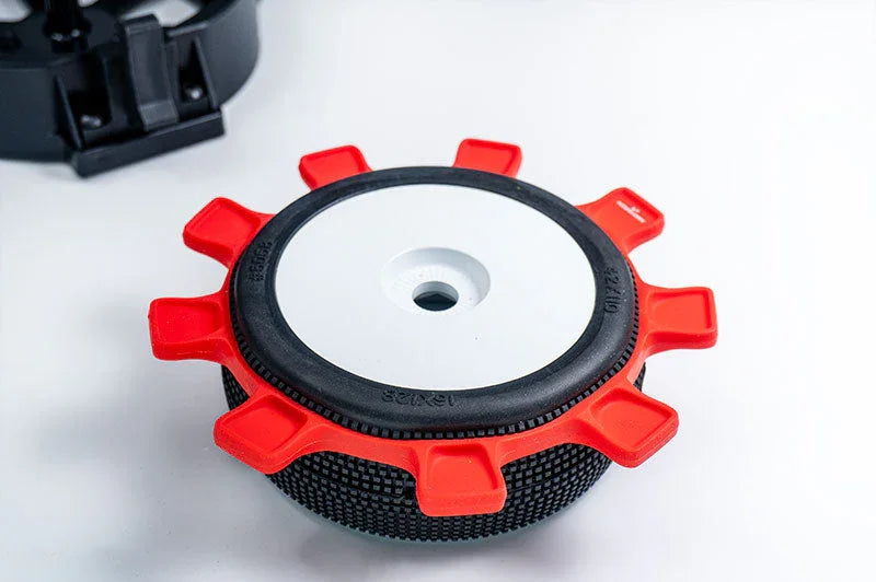 RC car tire tool with red silicone grips and textured black surface on a white background