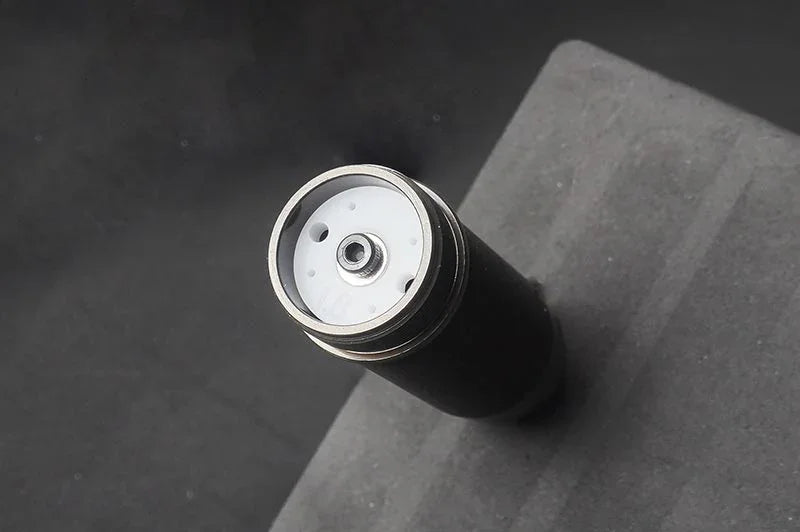 Close-up of RC shock absorber part on foam surface, silver and black detailing, RC car accessory
