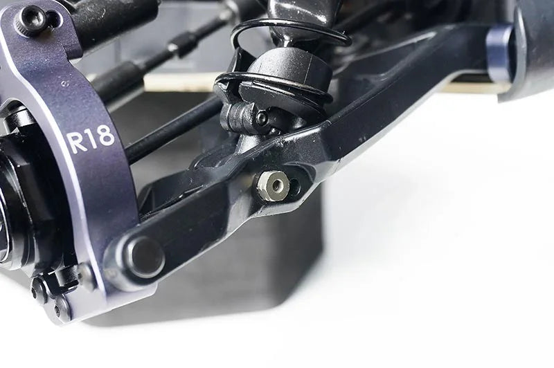Close-up of RC car suspension arm and R18 aluminum hub with spring and shock detail