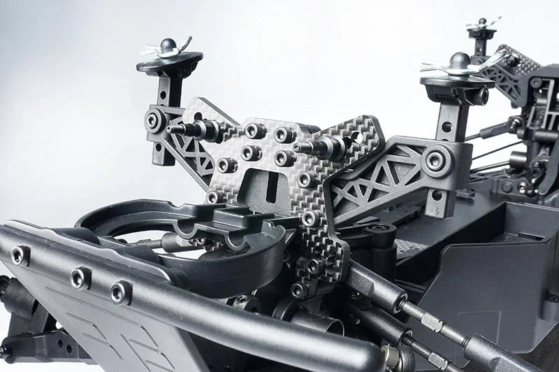 Close-up of RC car chassis with carbon fiber shock tower and suspension arms