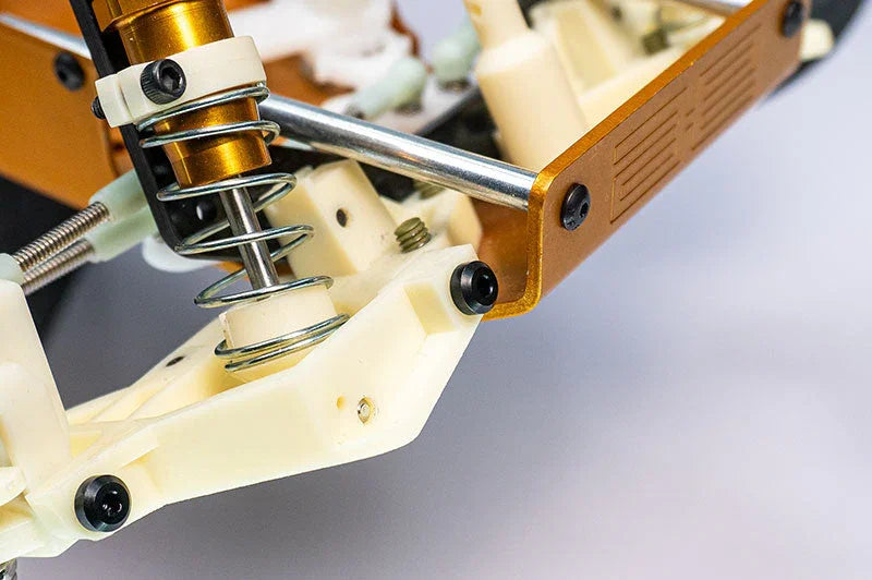 Close-up of RC car suspension system with metal shock absorber and chassis parts