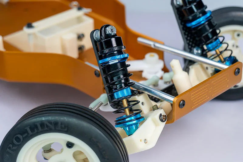 RC car front suspension close-up with blue aluminum shocks and off-road tire