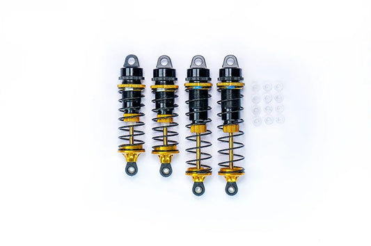 Set of four black and gold RC car shock absorbers with spare bushings on white background