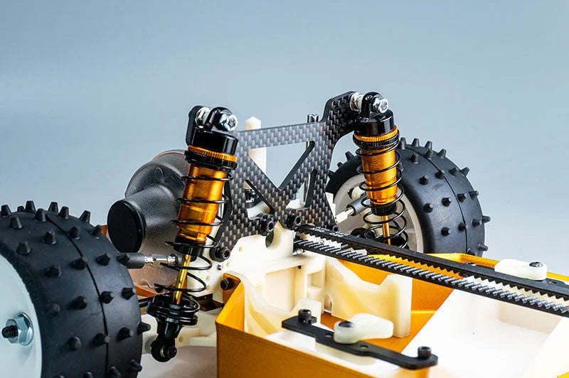 Close-up of RC car rear suspension with carbon fiber shock tower and spiked tires