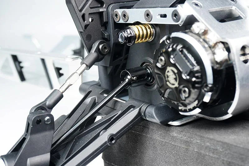 Koswork RC car metal gearbox, suspension arm, and shock absorber close-up