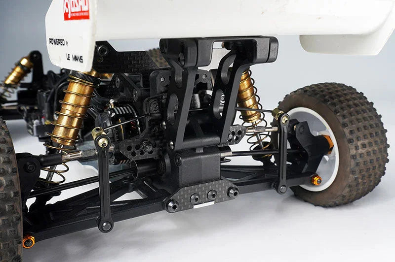 Close-up of RC car rear suspension with knobby tires and shock absorbers