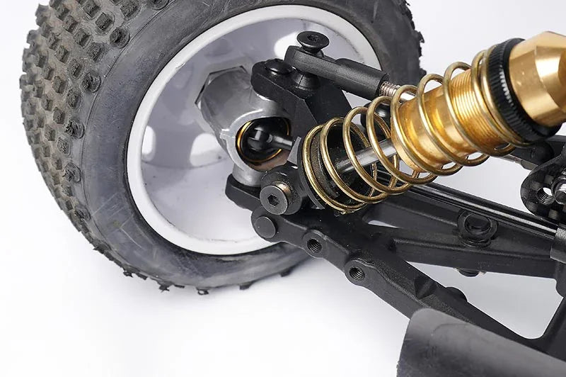 Koswork RC car rear suspension, gold shock absorber, black arm, off-road tire close-up