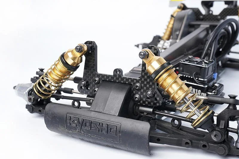 Koswork RC car gold aluminum shock absorbers and black carbon fiber chassis, close-up.