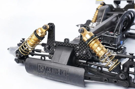 Koswork RC car gold aluminum shock absorbers and black carbon fiber chassis, close-up.