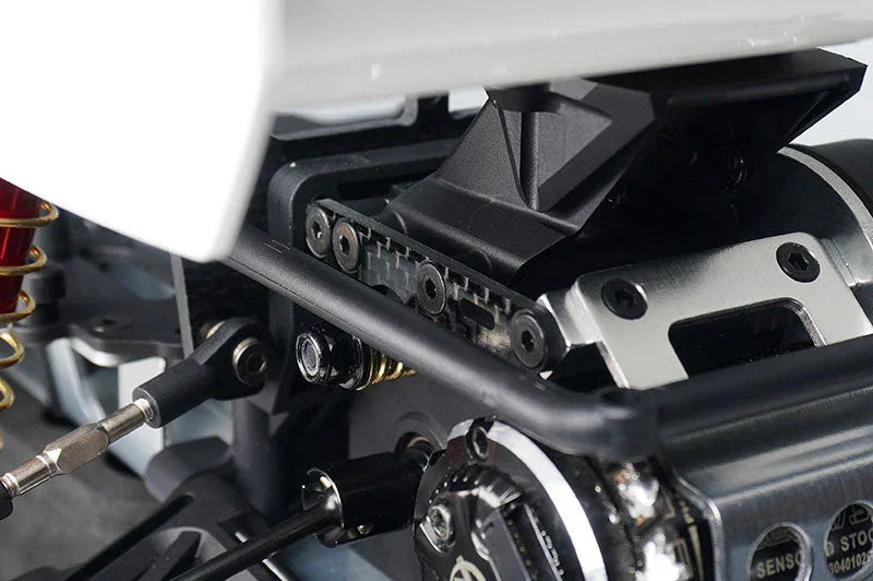 Close-up of RC car drivetrain components, including motor mount and shock absorber details