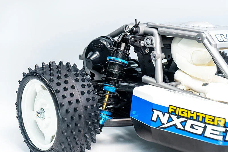 RC car close-up showing spiked rubber tire, blue suspension, and detailed body panel.