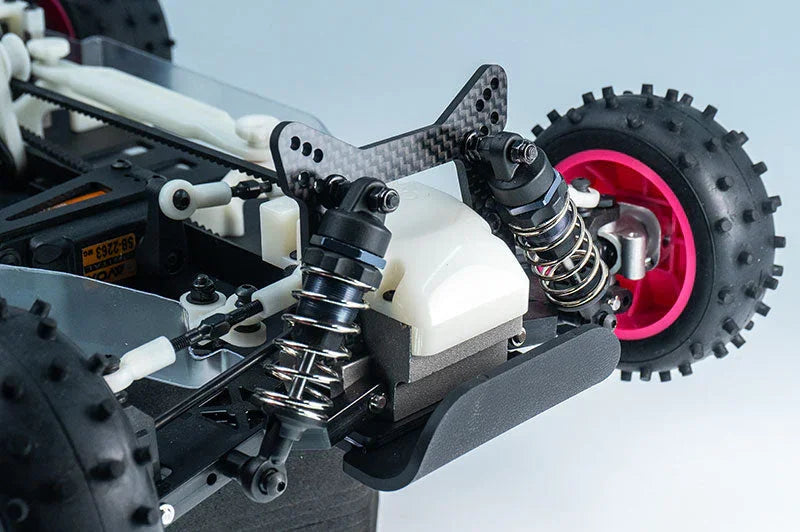 Close-up of RC car rear suspension, shock absorbers, and off-road tire with pink rim