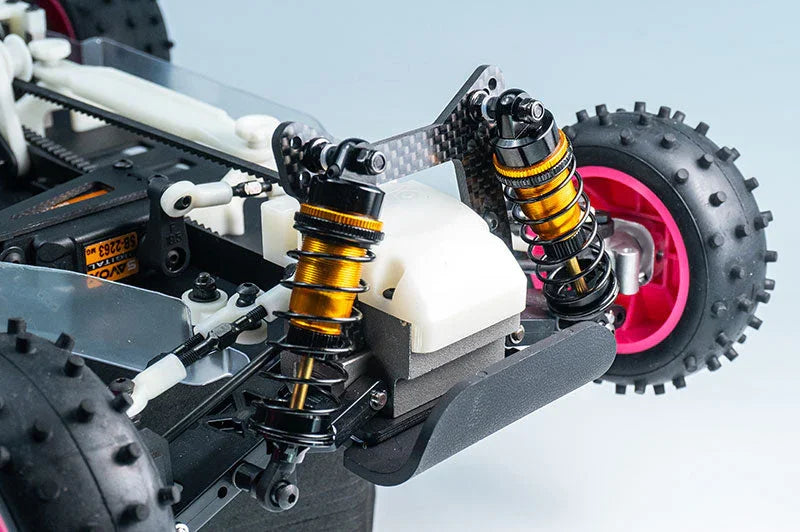 Close-up of RC car rear suspension with dual shock absorbers and spiked tires