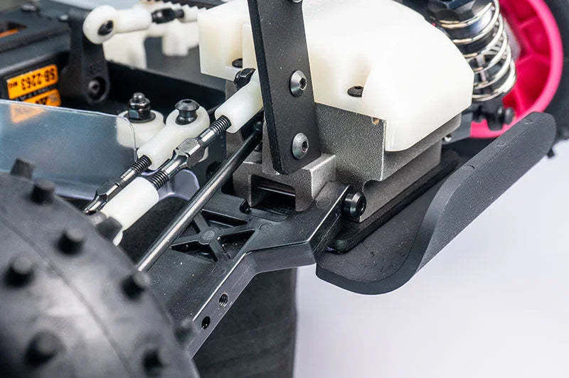 Close-up of RC car chassis with shock absorber, steering rods, and rugged rear tire