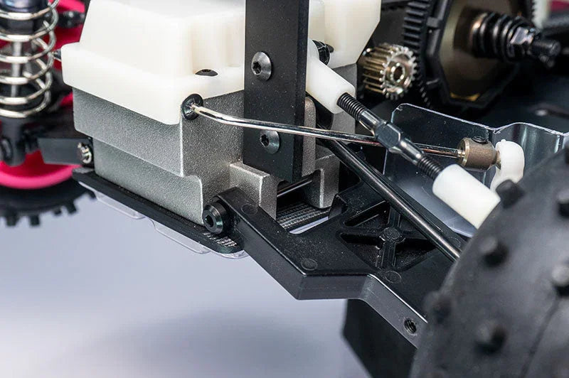 Close-up of RC car drivetrain and suspension parts with visible gears and linkage rods.