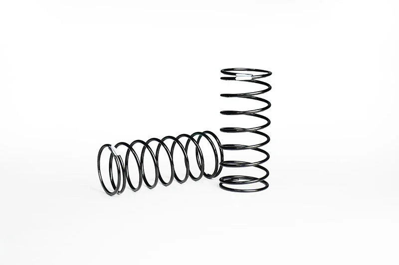 Two black RC car shock springs on white background, one standing and one laying down