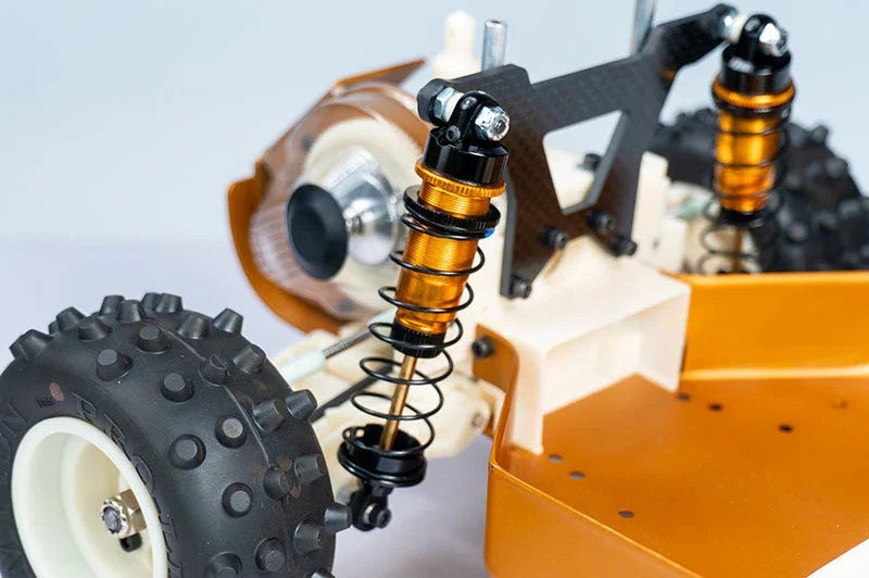 Close-up of RC car rear suspension, coilover shocks, and off-road tires