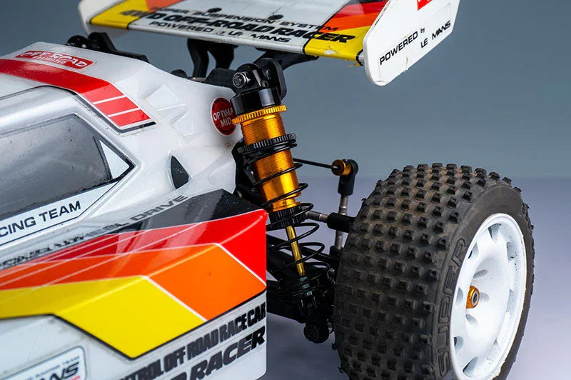 Close-up of RC off-road racing car with detailed suspension, knobby tire, and colorful decals