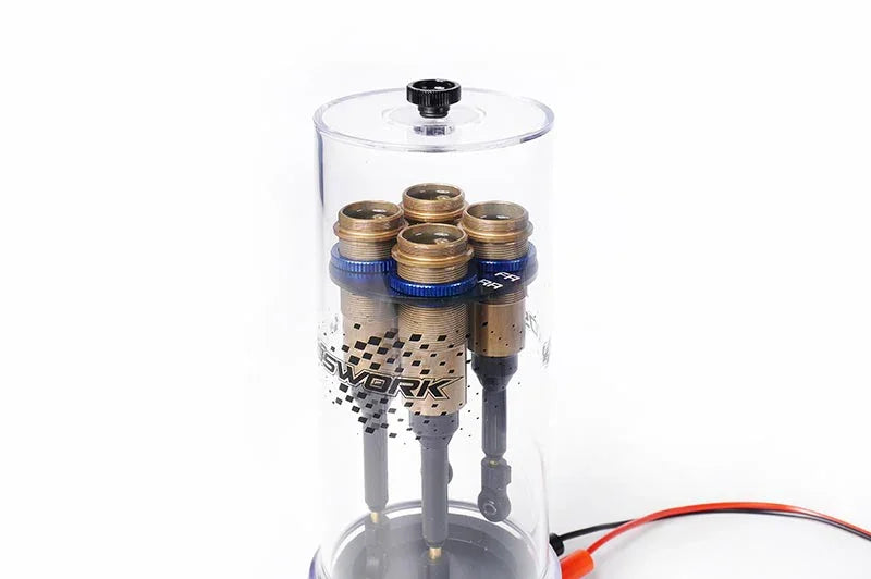 RC shock absorbers mounted in a transparent vacuum bleeding tool for RC car maintenance