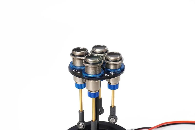 Close-up of four RC car shock absorbers with blue aluminum collars on white background