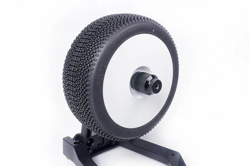 RC car tire with knobby tread pattern mounted on wheel and display stand