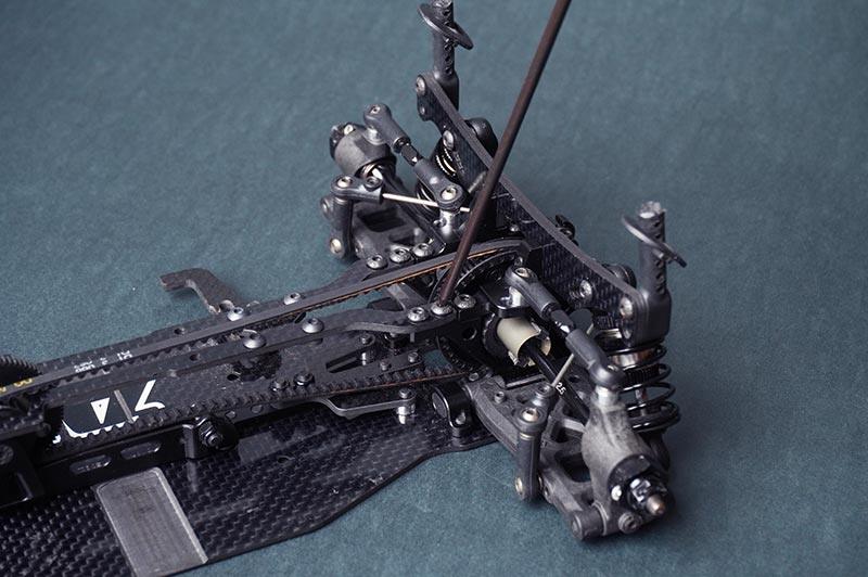Koswork RC car carbon fiber chassis and suspension detail, showcasing precision hobby parts