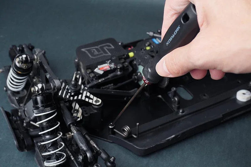Koswork RC hex driver tool KOS13204 used on black RC car chassis, ergonomic handle visible.