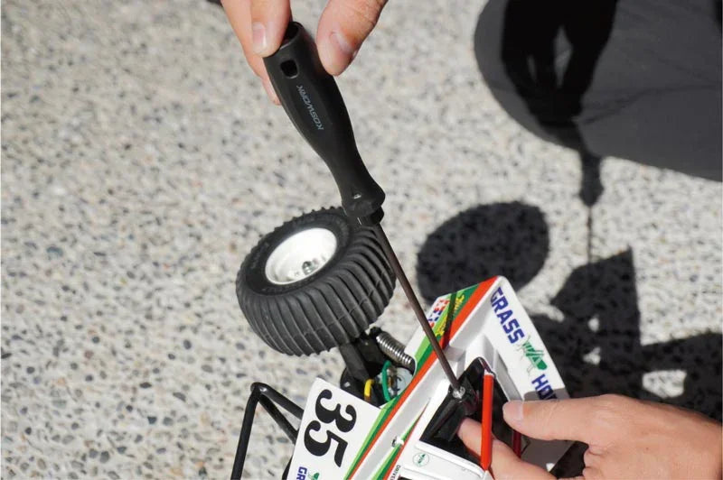 Koswork RC car tool with black handle adjusting model car, product KOS13204, outdoor setting.